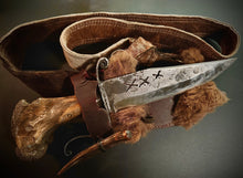 Load image into Gallery viewer, Decorative knife with leather sheath and fur accents on a dark background
